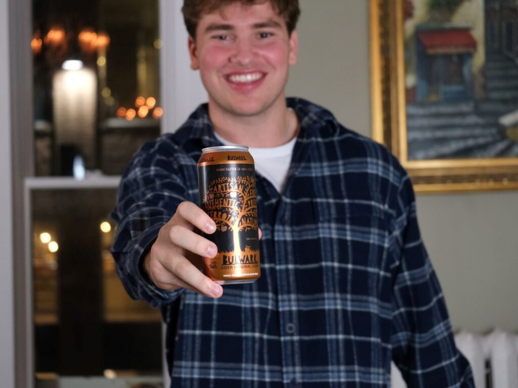 Young man in taproom holding can of Bulwark cider